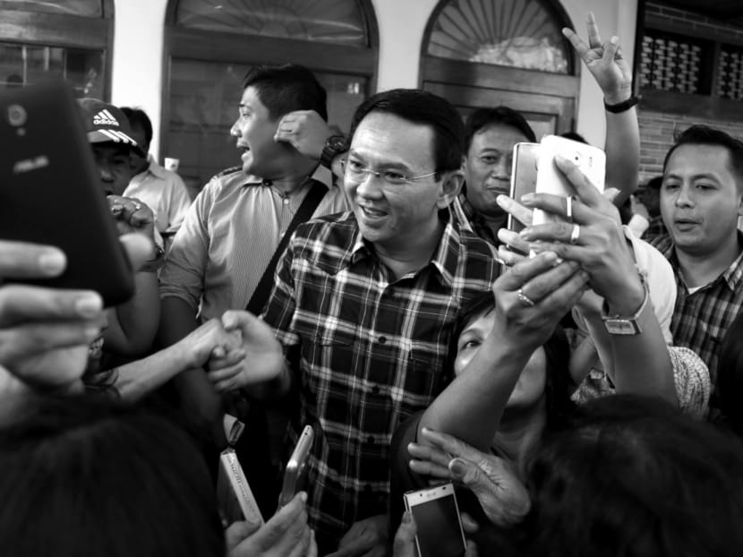 Jakarta Governor Basuki Tjahaja Purnama, popularly known as Ahok (centre), is mobbed by his supporters  during a campaign event in Jakarta. Mr Purnama has been named as a suspect in a blasphemy investigation in a major test of the Muslim-majority nation’s reputation for religious tolerance. Photo: AP