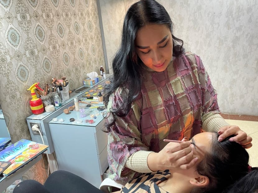 In this photograph taken on Oct 18, 2021, a beautician applies make-up to a customer at a beauty salon in Kabul.