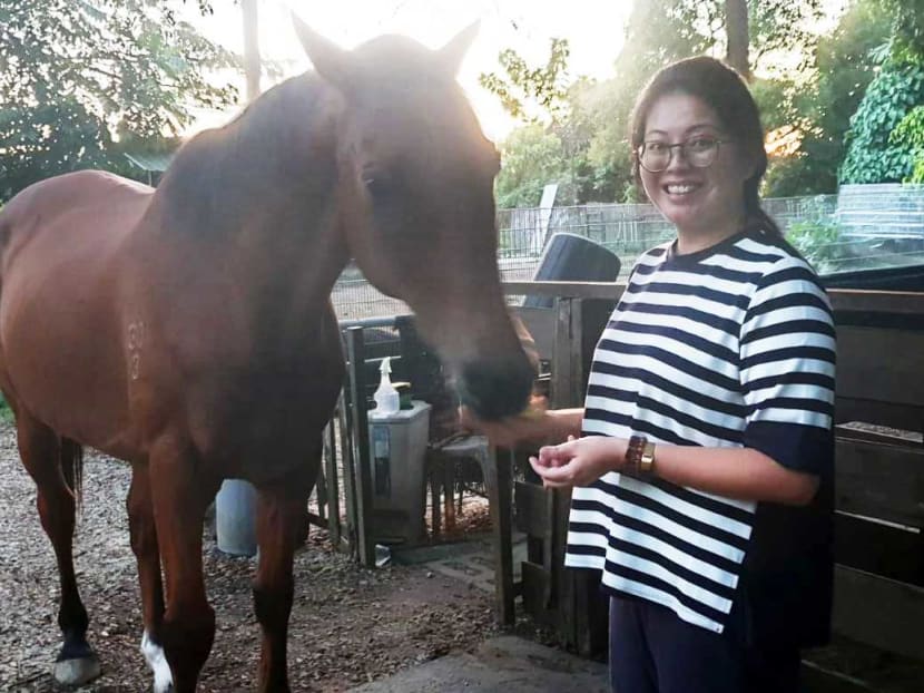 Ms Joanne Lim feeds a horse at The Animal Resort, a popular petting farm, which has been her family's home for 20 years.