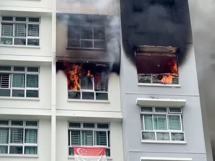 In a video posted by a Facebook user, a fire can be seen engulfing a flat as thick black smoke billows out from it, coating the exterior walls of the housing block with black soot. In a video posted by a Facebook user, a fire can be seen engulfing a flat as thick black smoke billows out from it, coating the exterior walls of the housing block with black soot.