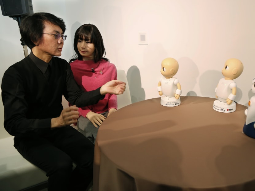 Japanese android expert Hiroshi Ishiguro, left, talks with new talking robot Sota, right, Android robot Otonaroid, second left, and another talking robots CommU, center and second right, during a press event at the National Museum of Emerging Science and Innovation Miraikan in Tokyo today (Jan 20). Photo: AP
