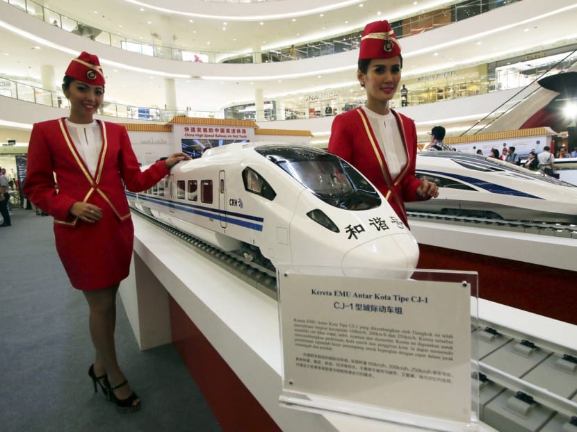 Attendants pose for a photo beside the models of a high speed train during the China High Speed Railway on Fast Track exhibition in Jakarta, Indonesia, August 13, 2015 in this file photo taken by Antara Foto. Photo: Reuters
