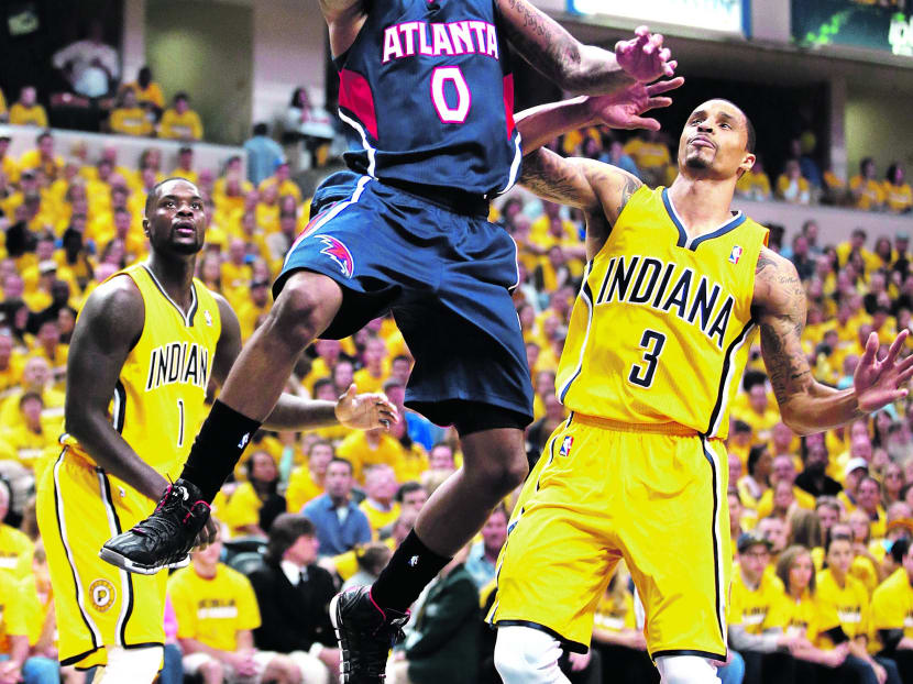 Atlanta Hawks’ Jeff Teague shooting against Indiana Pacers’ George Hill in Game 1 of an opening-round NBA basketball playoff series on Saturday in Indianapolis. Photo: AP