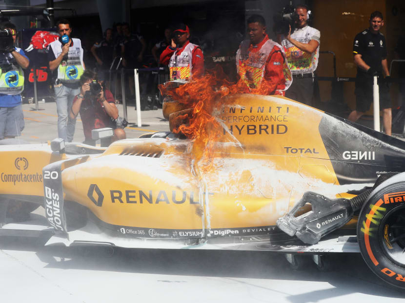 Kevin Magnussen's car on fire in the pit lane at the Sepang race track in Malaysia. Photo: Getty Images