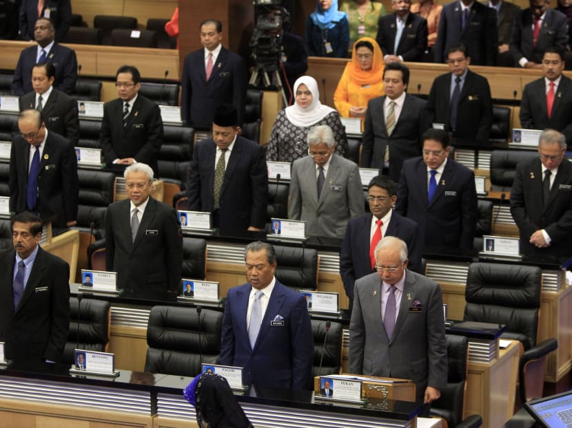 Members of Parliament stand for a moment of silence for the victims of the Malaysia Airlines Flight 17 before Malaysian Prime Minister Najib Razak, bottom right, tabling an emergency motion to condemn the suspected shooting of the Malaysia Airlines Flight 17 in eastern Ukraine, at the Parliament house in Kuala Lumpur, Malaysia, Wednesday, July 23, 2014. A team of Malaysian investigators visited the site along with members of the OSCE mission in Ukraine for the first time since the air crash last week. (AP Photo/Lai Seng Sin)