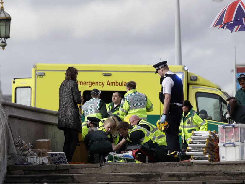 Emergency services staff provide medical attention close to the Houses of Parliament in London, Wednesday, March 22, 2017. Photo: AP