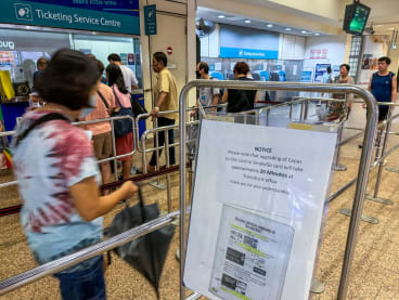 A sign at Tampines MRT station on Jan 16, 2024, informing commuters of a 20-minute waiting time to upgrade Ez-link adult cards to SimplyGo cards.