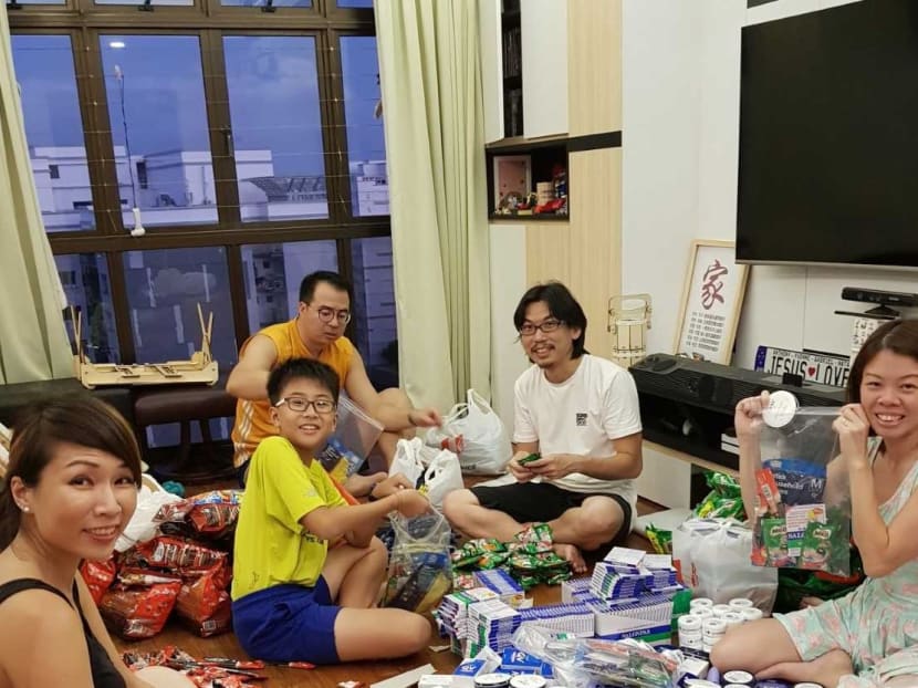 (From left): Ms Yvonne Kong-Ho, her son Gabriel Ho, her husband Mr Anthony Ho, and friends Mr Daniel Li and Ms Sharon Lim packing welfare packs for cleaners at Ms Kong-Ho’s flat
