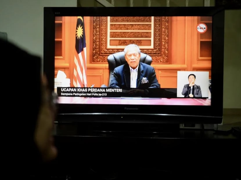People watch the live telecast of Malaysian Prime Minister Tan Sri Muhyiddin Yassin announcing an extension to the movement control order on March 25, 2020.