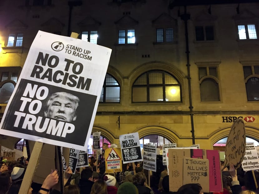 Demonstrators hold banners during a protest against US President Donald Trump's controversial travel ban on refugees and people from seven mainly-Muslim countries, in Oxford, England on Jan 30, 2017. Photo: AP