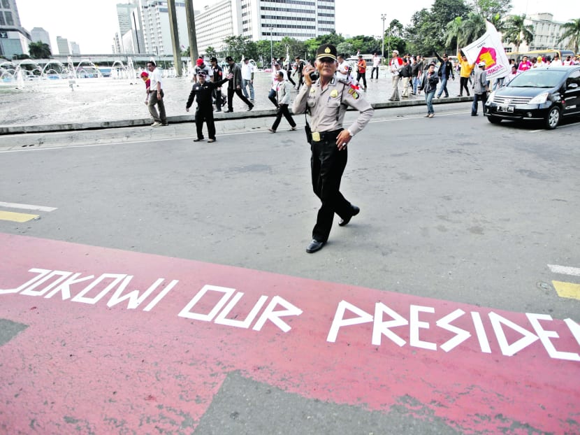Mr Widodo’s supporters taped a message with the words ‘Jokowi our President’ on a Jakarta road, despite 
his calls for them to stand down on Wednesday night. Photo: AP