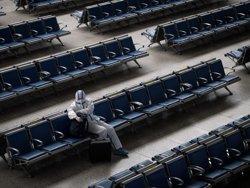 A passenger wears a hazmat suit as a precaution against the Covid-19 coronavirus as he waits for a train at Hankou Railway Station in Wuhan, in China's central Hubei province on May 2, 2020.