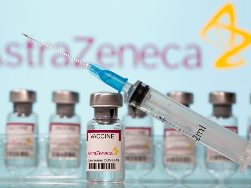 Vials and a syringe are seen in front of an AstraZeneca logo in this illustration taken March 10, 2021.