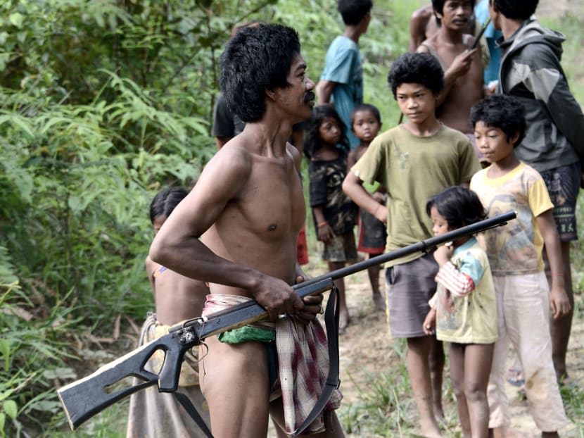 An Indonesian "Orang Rimba" tribesman brandishing a homemade rifle and wearing a loincloth, part of a hunting party, setting out through palm oil trees in a desperate hunt for prey in an area that was once lush rainforest in the Batang Hari district of Jambi province. Photo: AFP