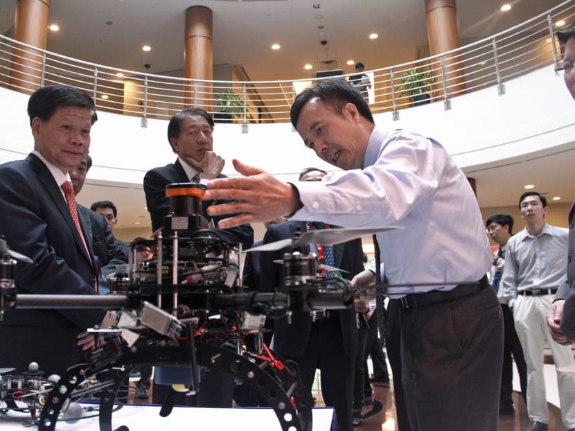 Deputy Prime Minister Teo Chee Hean introduced to some of the robotic systems at the launch of ST Engineering and NTU's joint-research laboratory. Photo: Tristan Loh