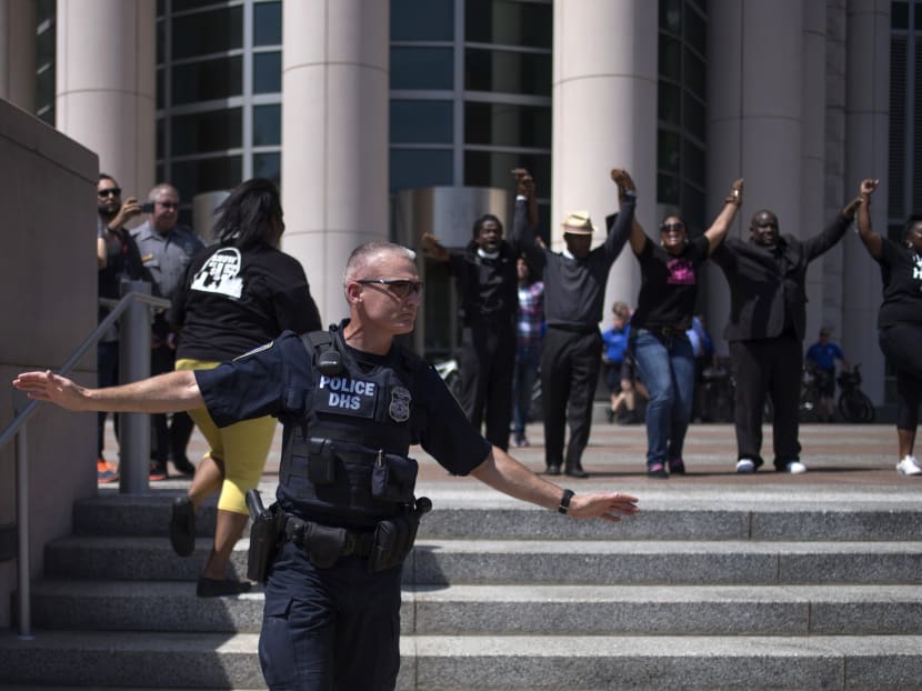 Activists raise their hands in solidarity after breaking past a policeman to demand justice for the killing of Michael Brown at the Thomas F Eagleton United States Courthouse in downtown St. Louis, Missouri, Aug 26, 2014.  Photo: Reuters