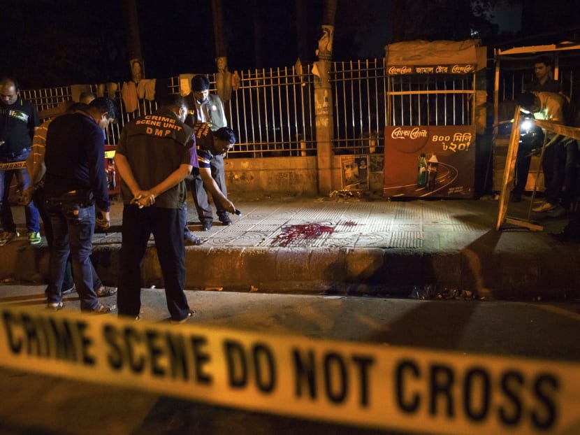 Bangladeshi policemen investigate at the site of attack on Avijit Roy, in Dhaka, Bangladesh, yesterday (Feb 26). Photo: AP