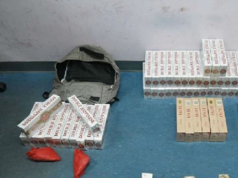 A follow-up search of Bao’s rented room in a unit of the condominium resulted in the seizure of 52 cartons and four opened packets of duty-unpaid cigarettes. Photo: Singapore Customs