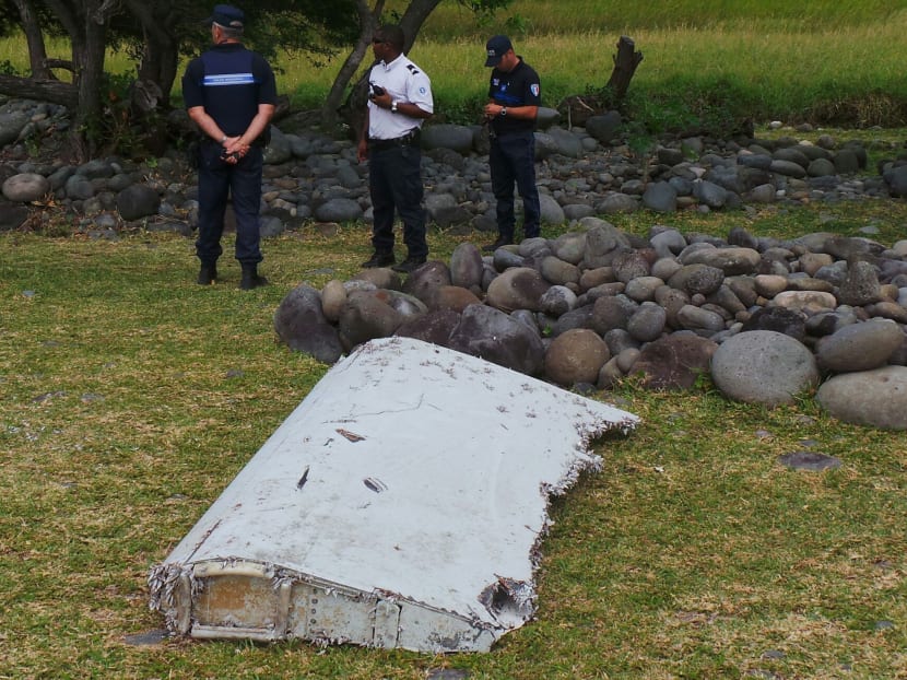 French gendarmes and police stand near a large piece of plane debris which was found on the beach in Saint-Andre, on the French Indian Ocean island of La Reunion, on July 29, 2015. Photo: Reuters