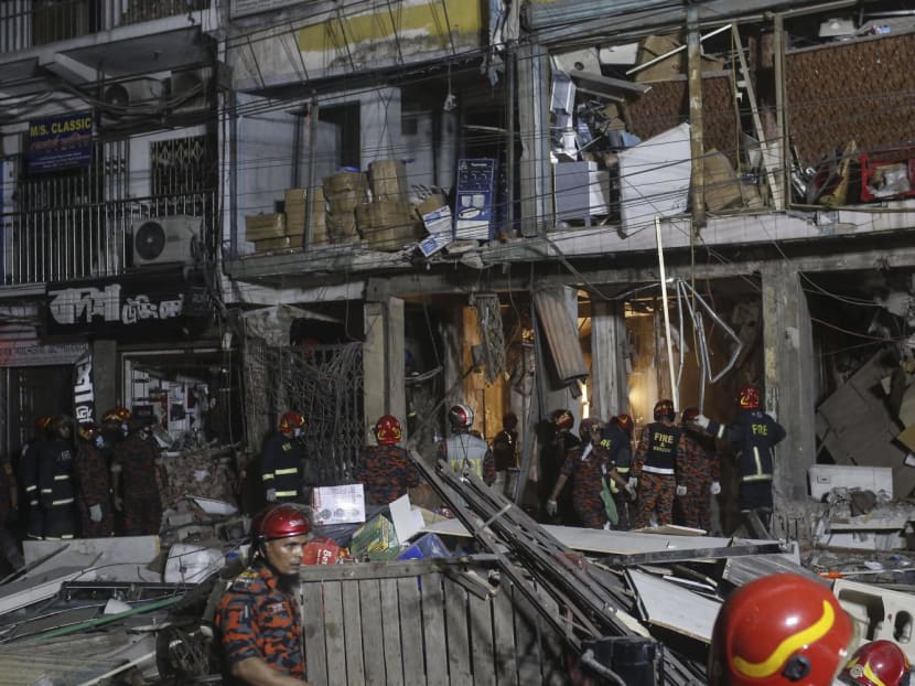 Firefighters work amid debris following an explosion inside an office building in Dhaka on March 7, 2023.