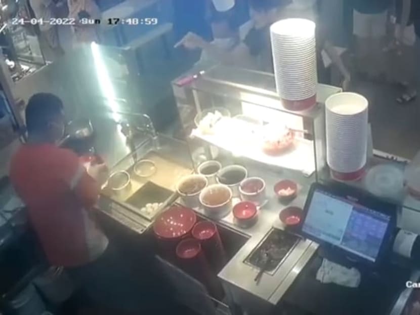 A screengrab from the video circulating on social media showing a conversation between the hawker and the young man before the latter flipped a tray across the counter.
