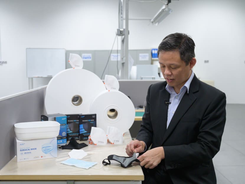 Trade and Industry Minister Chan Chun Sing inserting the filter produced by ST Engineering into a reusable face mask at the firm's Tuas facility on Jan 28, 2021.