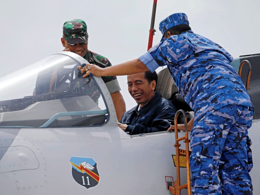 Indonesia's President Joko Widodo smiles as he sits in the cockpit of a Sukhoi fighter in this file photo. The writer notes that the defence expenditures of several big-spender countries measured as a share of their national GDP have in some cases stagnated (Indonesia) or even slightly decreased (Singapore) in recent years. Photo: Reuters