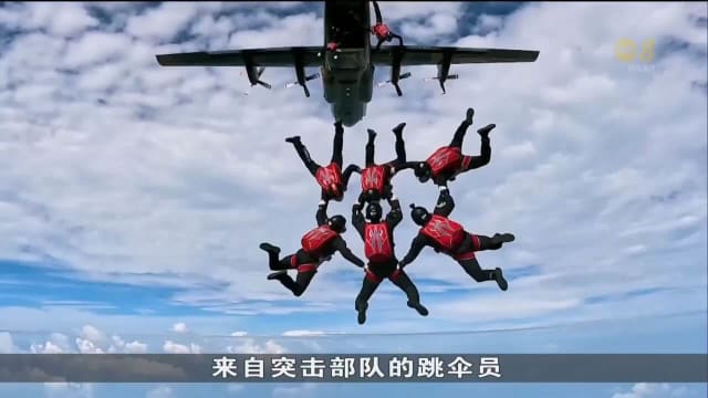 八名跳伞员从1万英尺高空一跃而出 集合在舞台中央向公众敬礼