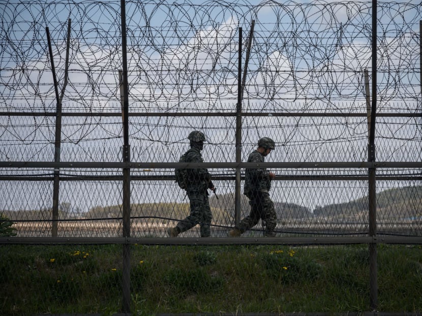South Korean soldiers patrol along a barbed wire fence Demilitarized Zone (DMZ) separating North and South Korea, on the South Korean island of Ganghwa on April 23, 2020.