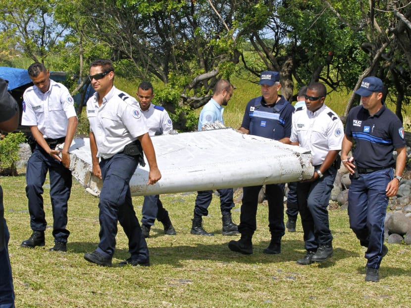 In this photo dated Wednesday, July 29, 2015, French police officers carry a piece of debris from a plane in Saint-Andre, Reunion Island. Photo: AP