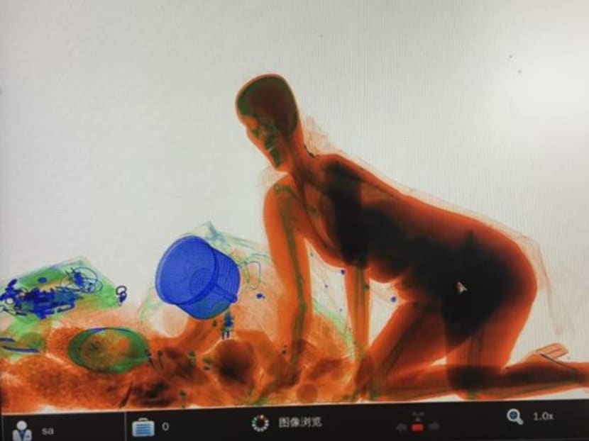 A woman in southern China accompanied her purse through a train station's luggage X-ray machine rather than part with the bag amid the Chinese New Year holiday rush, Chinese media reported. Photo: Screenshot from YouTube channel of People's Daily