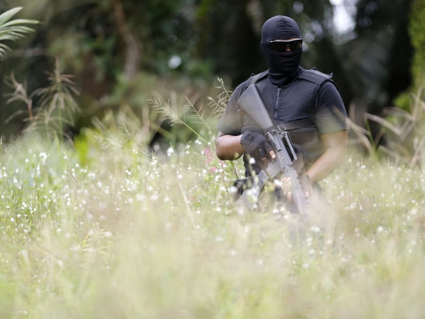A special police force guards the area about three kilometres away from the location where armed men are holding off, during a visit by a minister in Sahabat 17 plantation farm, outside Lahad Datu on Borneo island on Feb 19, 2013. 
