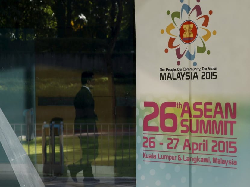 A man passes a banner for the 26th ASEAN summit in Kuala Lumpur, Malaysia. Photo: Reuters