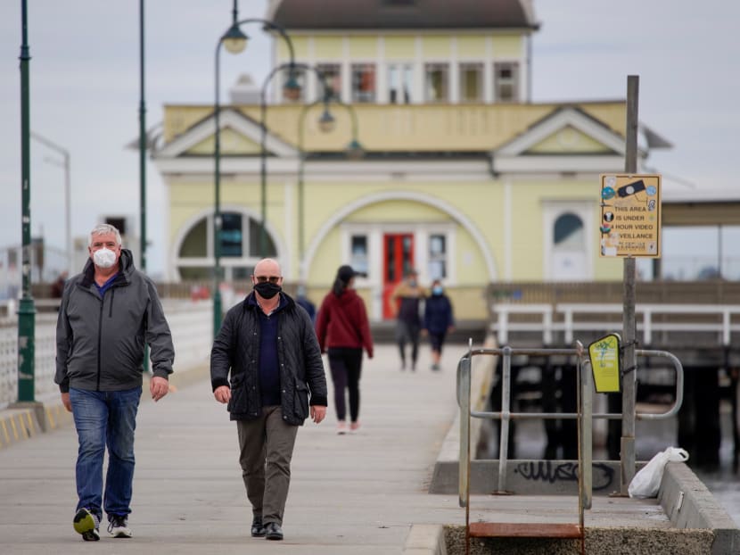 Walkers wear protective face masks at St Kilda pier in Melbourne after it became the first city in Australia to enforce mask-wearing in public as part of efforts to curb a resurgence of Covid-19 on Thursday, July 23, 2020.