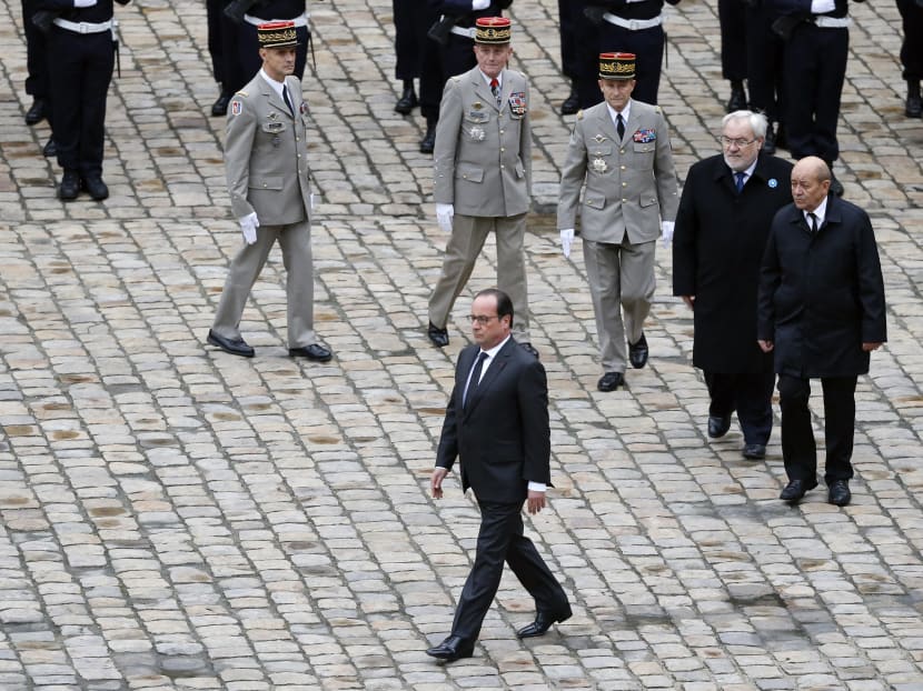 French President Francois Hollande, followed by, from top left, French army general Bruno Le Ray, military governor of Paris, French President Hollande's Military Chief of Staff General Benoit Puga, French Army Chief of Staff, General Pierre de Villiers, French Junior Minister for Veterans and Remembrance, Jean-Marc Todeschini, and French defense minister Jean Yves Le Drian, attend a Military ceremony at the Military Hotel National des Invalides, in Paris on Nov 19, 2015. Photo: AP