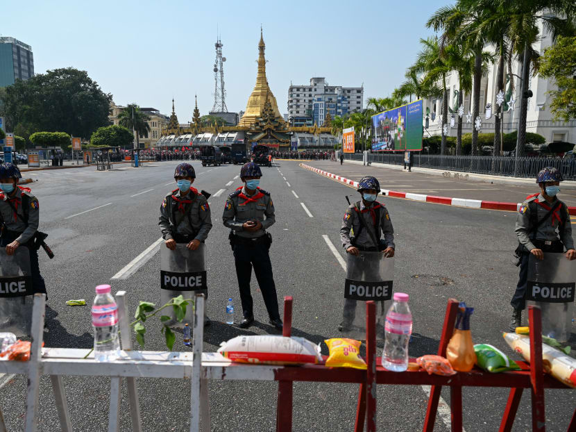 Police stand guard on a street during a demonstration against the military coup near Sule Pagoda in Yangon on February 7, 2021.