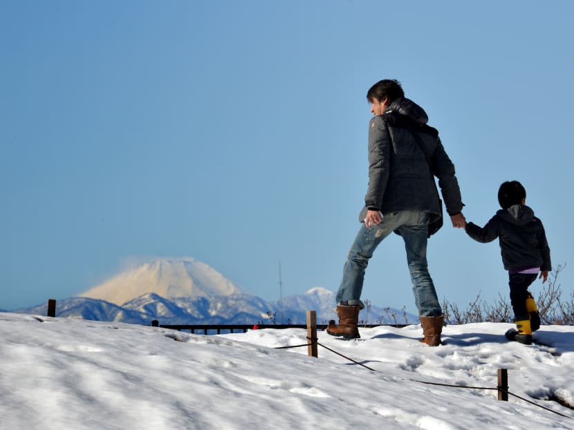 A father walking with his son in a snow-covered field in Tokyo. The average age at which men become a father in Japan has been rising every year in Japan, standing at 32.7 years in 2015, said a survey conducted by the Ministry of Health, Labour and Welfare.
Photo: AFP