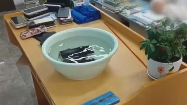 学生违规带手机回宿舍 中国学校竟将手机泡水里