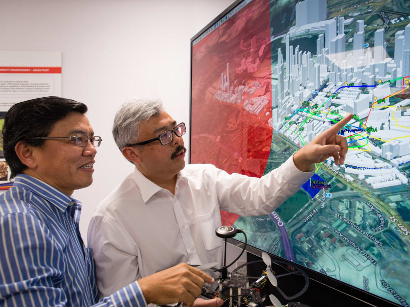 NTU Professor Low Kin Huat (left) and Air Traffic Management Research Institute’s Deputy Director Mr Mohamed Faisal Bin Mohamed Salleh discussing an NTU-developed air traffic simulation, which takes into account various solutions to enable safe and efficient drone travel in Singapore. Photo: NTU