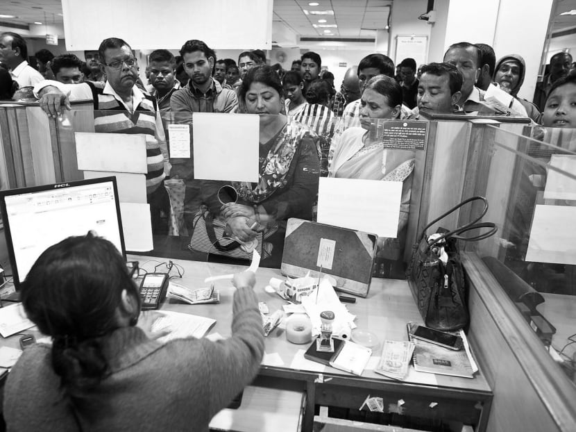 Indians depositing discontinued notes on the last day in a bank in Gauhati, India, on Dec 30. Since November, an estimated 97 per cent of the banned notes have been deposited in banks or exchanged for other denominations. Car sales saw their biggest drop in 16 years last month as the ban took effect. Photo: AP