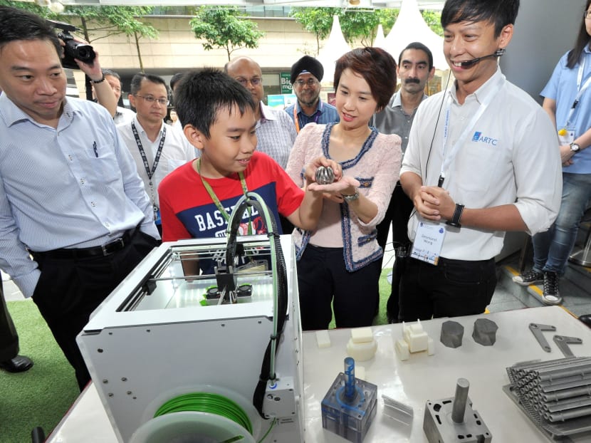 Ms Low Yen Ling, the Parliamentary Secretary for Ministry of Education & Ministry of Trade and Industry, observing how 3D printing works at The Future Workplace @ Advanced Remanufacturing and Technology Centre (ARTC) booth at the one-north Festival. Photo: A*Star