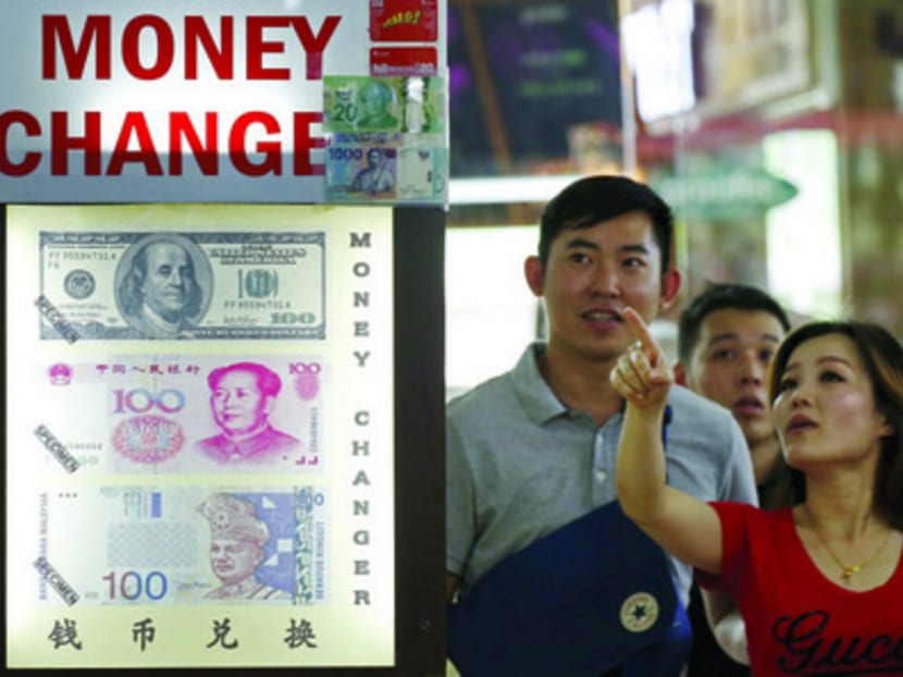 The ringgit’s free-fall led to a surge in demand for the currency in Singapore, with many people flocking to money changers yesterday. Photo: REUTERS