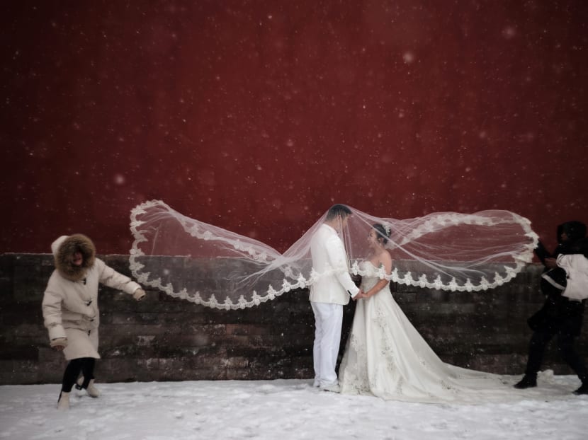 Photo of the day: A couple poses for a wedding photo shoot amid snowfall at the Imperial Ancestral Temple in Beijing, China.