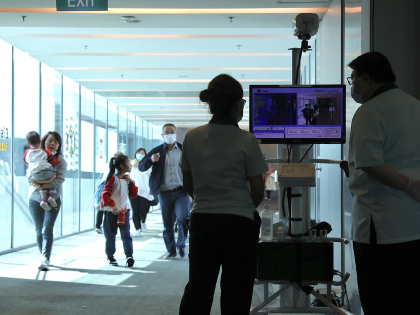 Border screeners monitor a thermal scanner set up at Changi Airport Terminal 3 to screen passengers coming in on a flight from Hangzhou, China on Jan 22, 2020. Changi Airport has set up more than 35 scanners across all four terminals to screen passengers coming in from over 430 flights from China each week.