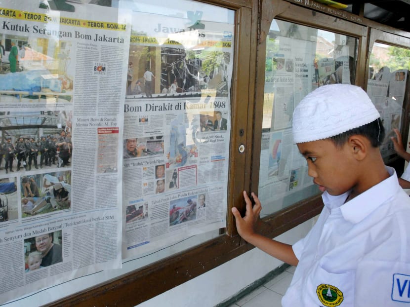 An Indonesian student at an Islamic boarding school built by Muslim cleric Abu Bakar Bashir, the spiritual head of the Jemaah Islamiyah, reads a local daily reporting on the July 17 bombing in Solo on July 22, 2009. The JI drew up plans to attack over 80 targets in Singapore. 