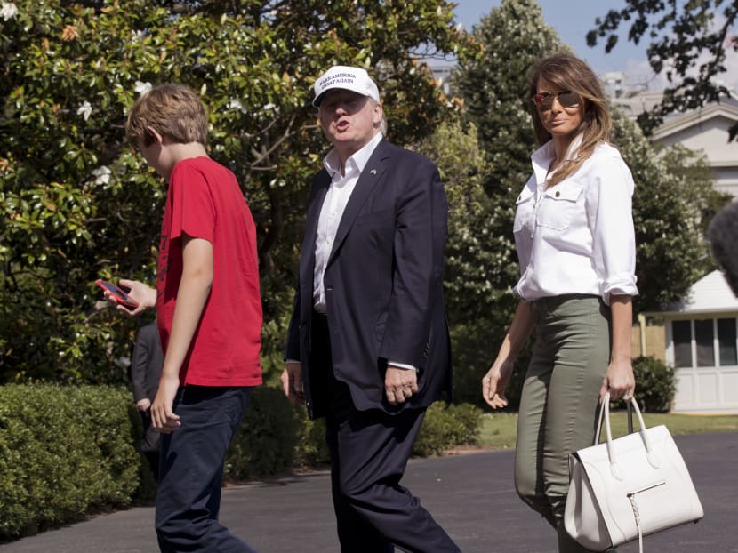 President Donald Trump, center, with first lady Melania Trump and their son Barron Trump, responds to a reporter's question upon arrival at the White House in Washington, Sunday, June 18, 2017, from Camp David in Maryland. Photo: AP