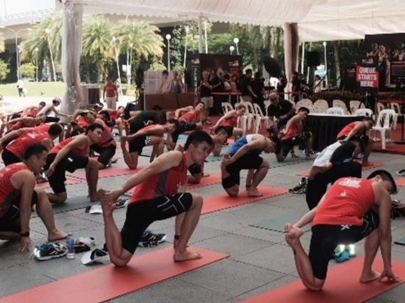 Runners of today's (April 11) lead-up run in a cool-down stretching yoga session at the roadshow event at VivoCity. Photo: Loke Kok Fai