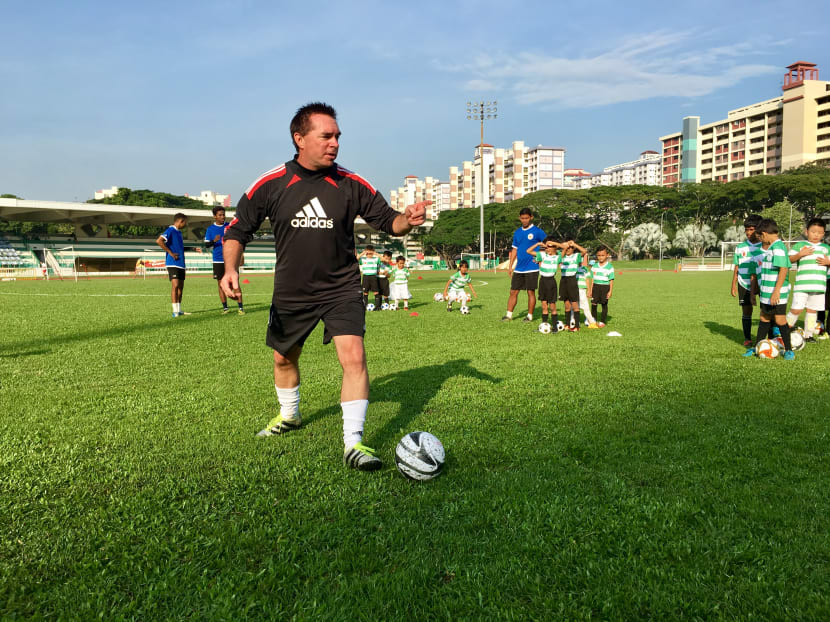 Tom Byer, a renowned football youth development coach, showing 40 children from the ActiveSG Football Academy how to execute a skill move at Bedok Stadium on Saturday, November 12, 2016. Photos: Stanley Ho/TODAY