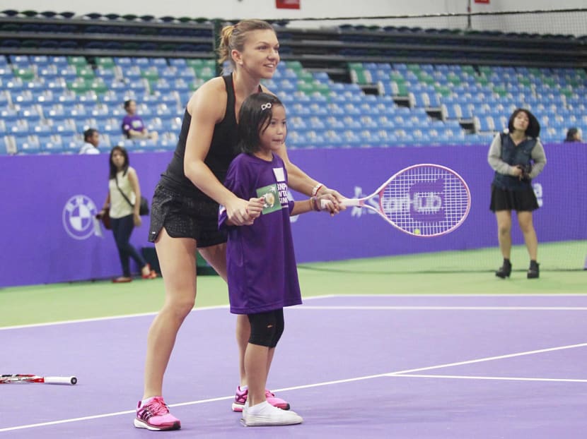 WTA Tennis player Simona Halep coaching one of the girls during SportCares tennis clinic at Singapore Sports Hub   yesterday. PHOTO BY WEE TECK HIAN