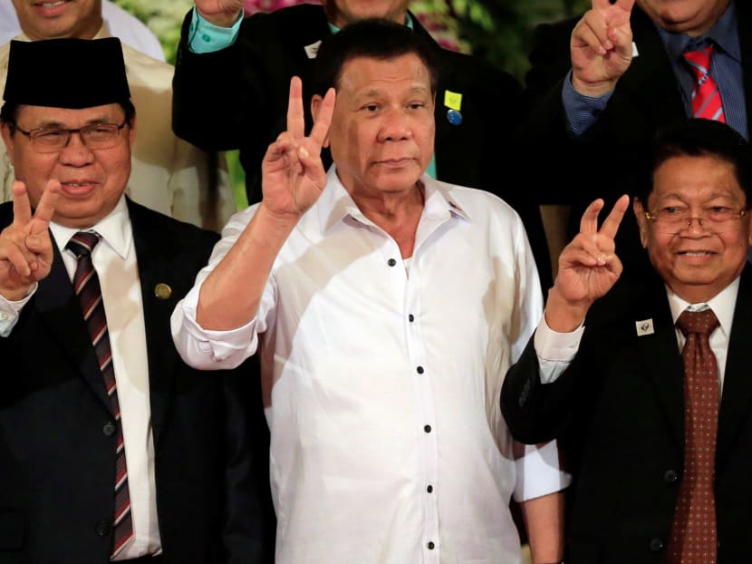 Philippine President Rodrigo Duterte (centre) with Moro Islamic Liberation Front chairperson Al Haj Murad Ebrahim (left) and Ghazali Jaafar, MILF vice-chairman during a handover of a draft law of the Bangsamoro Basic Law (BBL) in a ceremony at the Malacanang presidential palace in metro Manila, July 17, 2017. Photo: Reuters